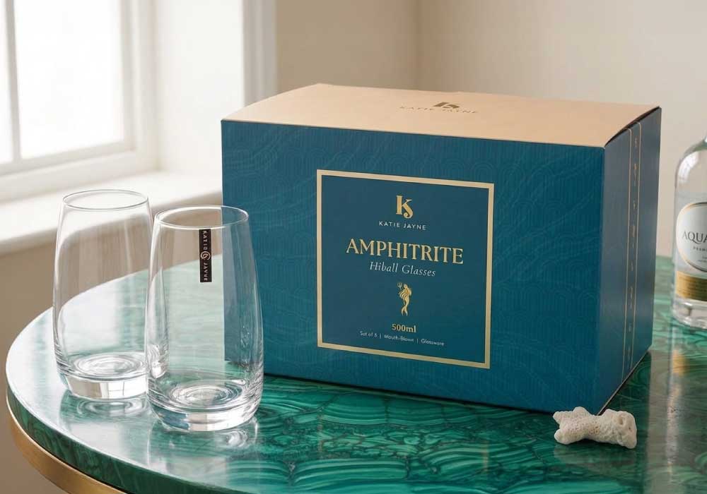Hiball Glassware packaging design for Katie Jayne and there new product Amphitrite product range, featuring a wavy green texture on the box, in situ with two of the glasses and a whiskey bottle in the background